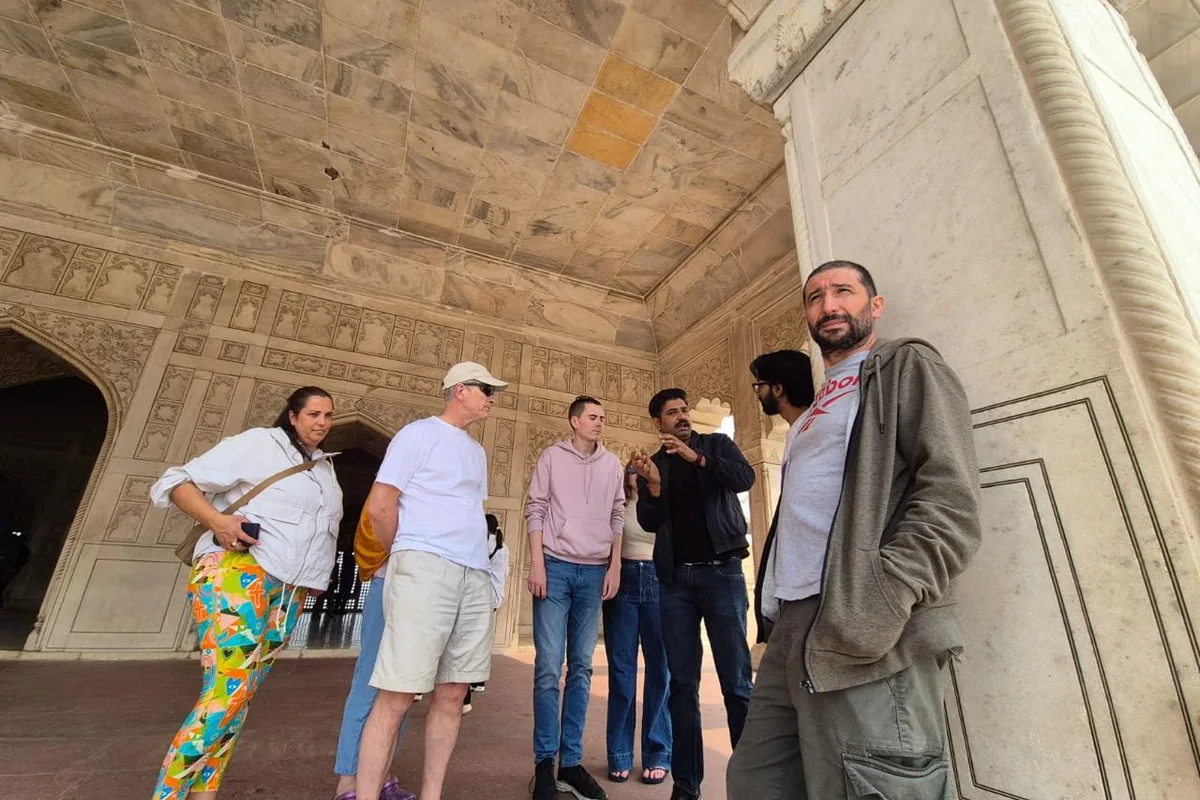 Visitors exploring an ornate historic palace in India