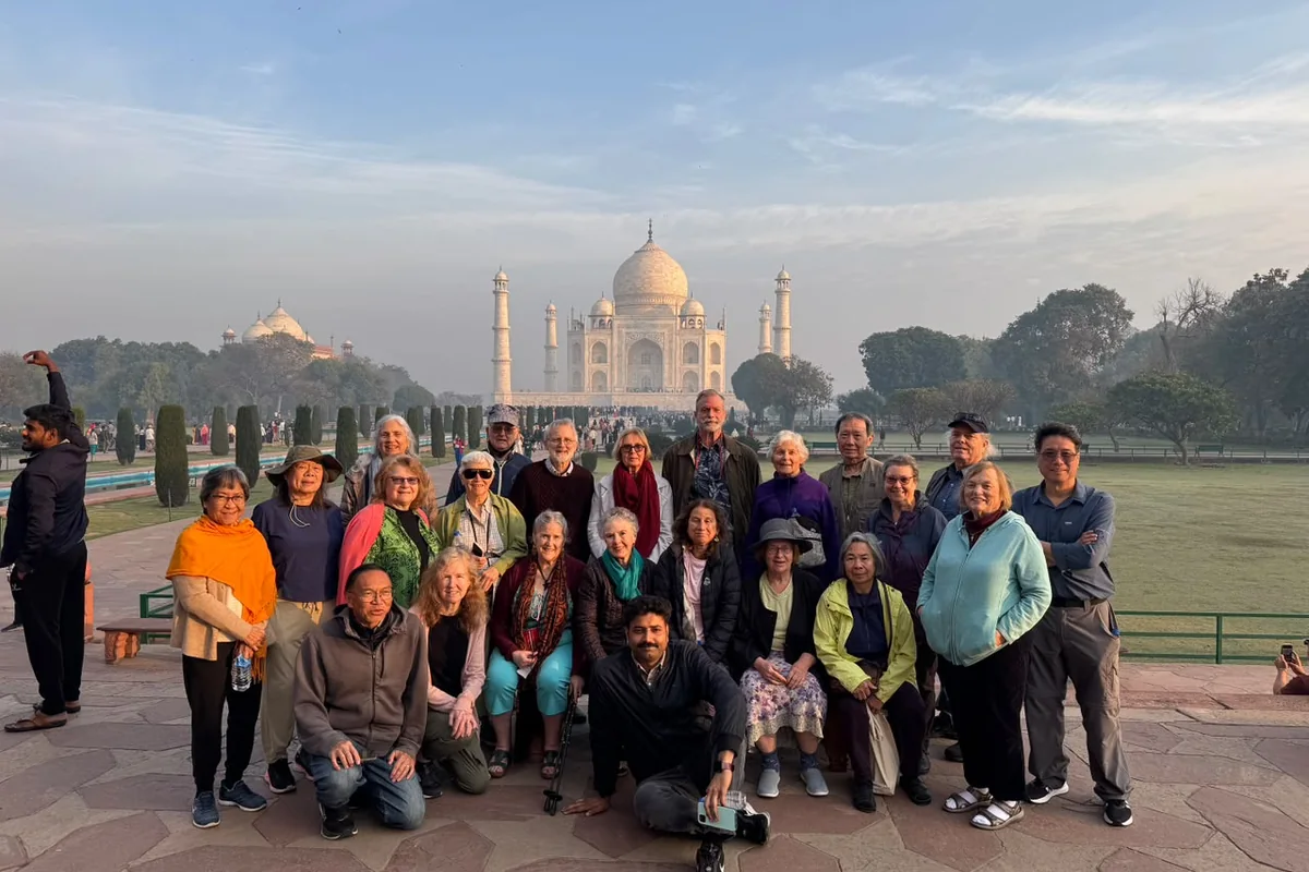 Group of travellers posing with the Taj Mahal in the background
