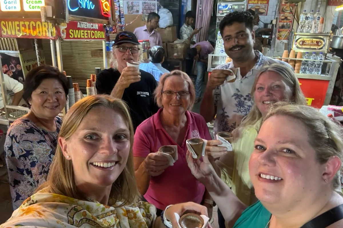 Guests smiling and sampling refreshments at an Indian market